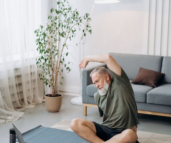 Cozy corner of a room with a yoga mat, plants, and soft light.